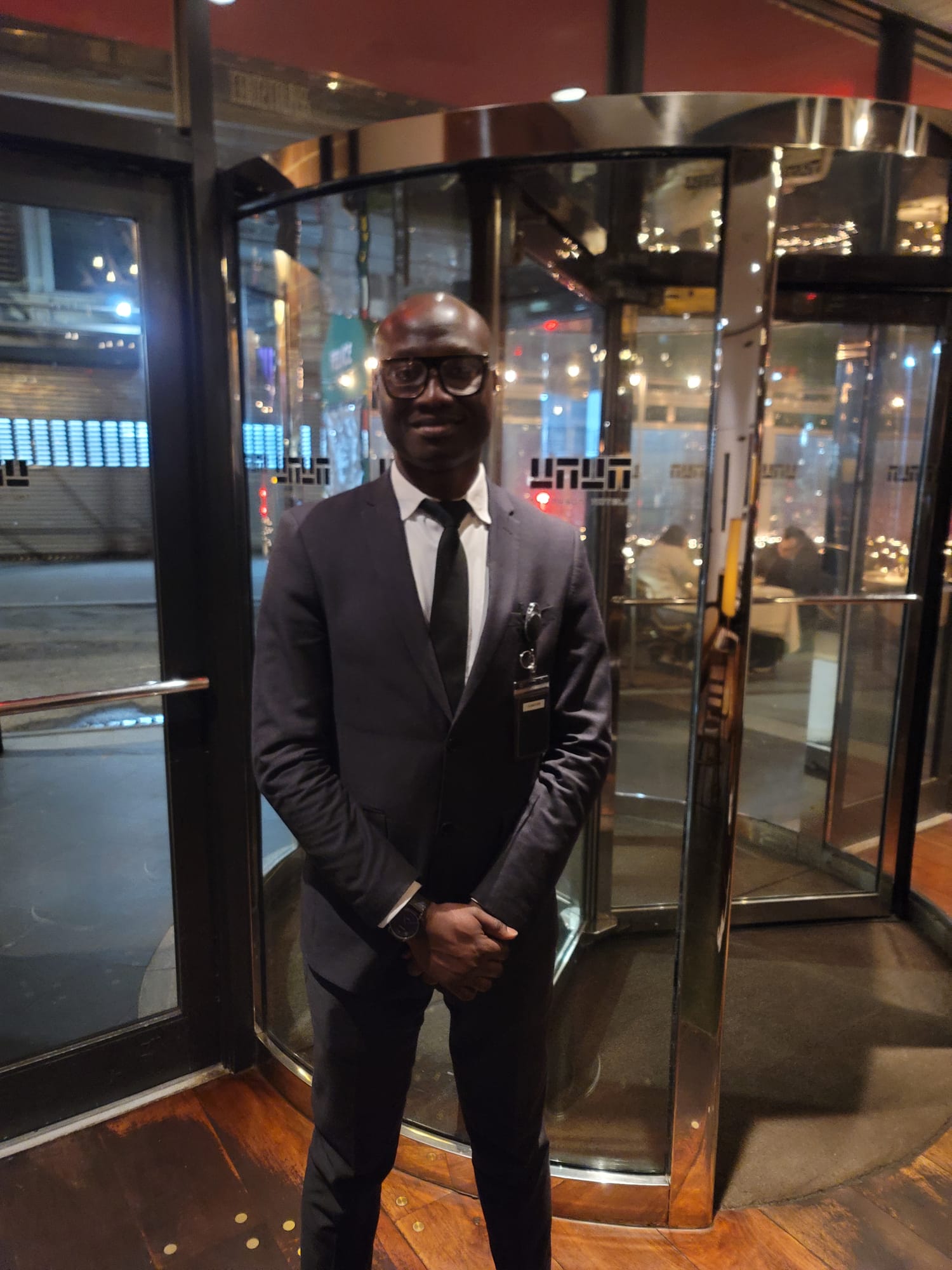 Professional security guard standing at building entrance with revolving door