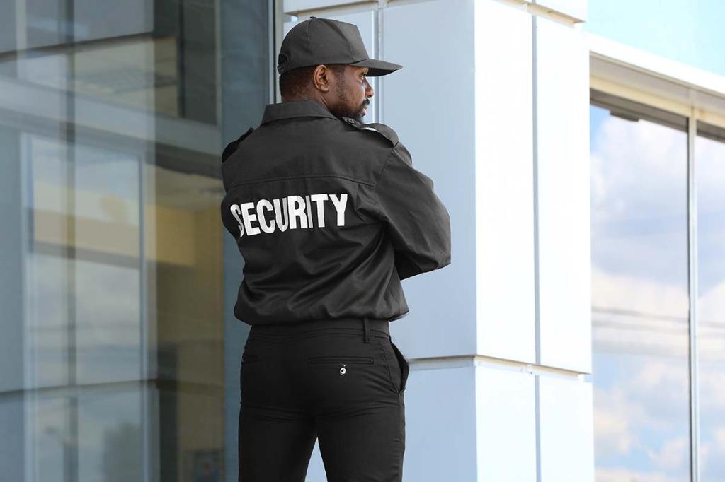 Professional security guard standing outside commercial building – Yellowstone Security Services
